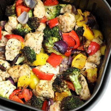 cooked chicken and veggies in the air fryer basket.