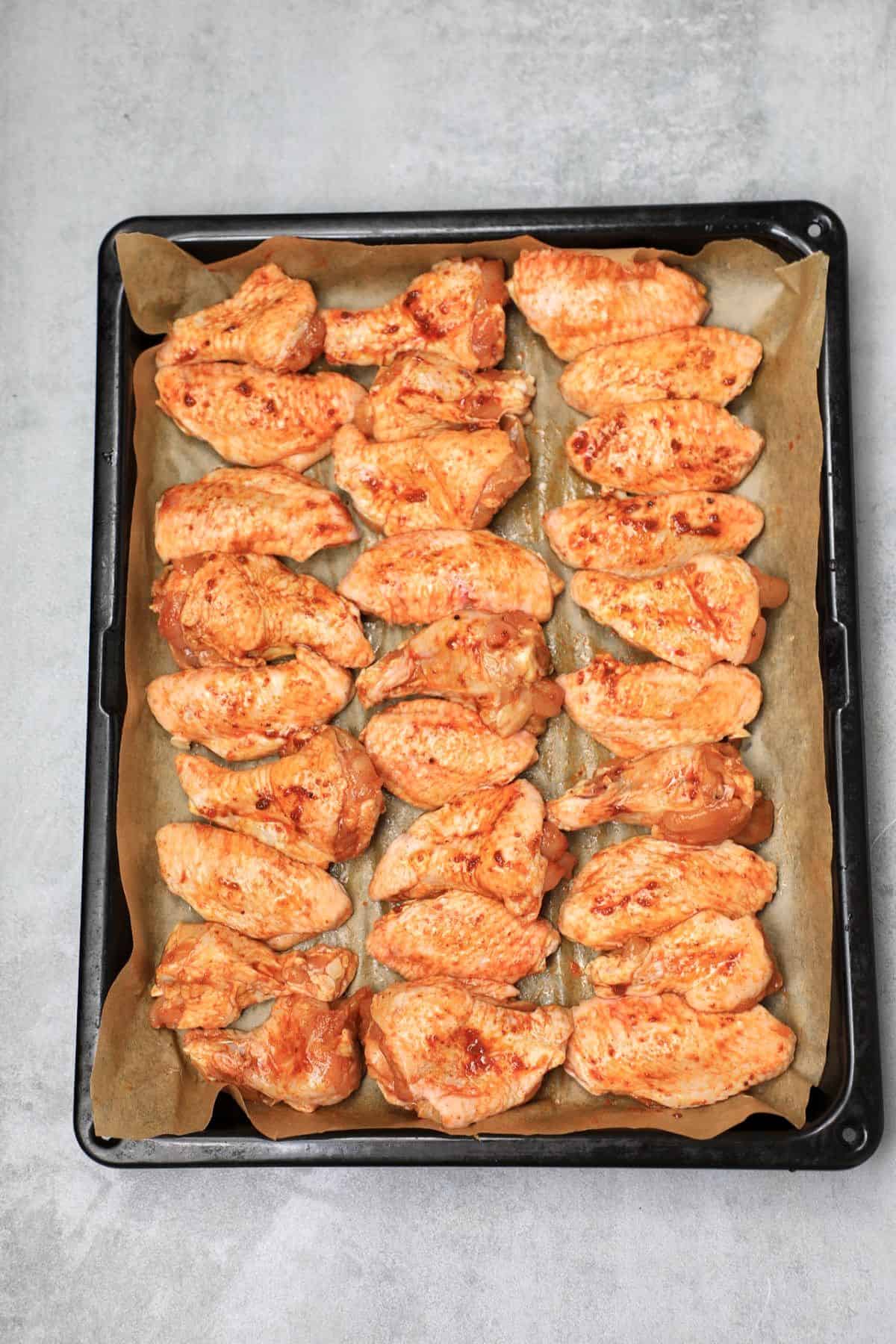 the wings arranged on a baking paper lined tray.