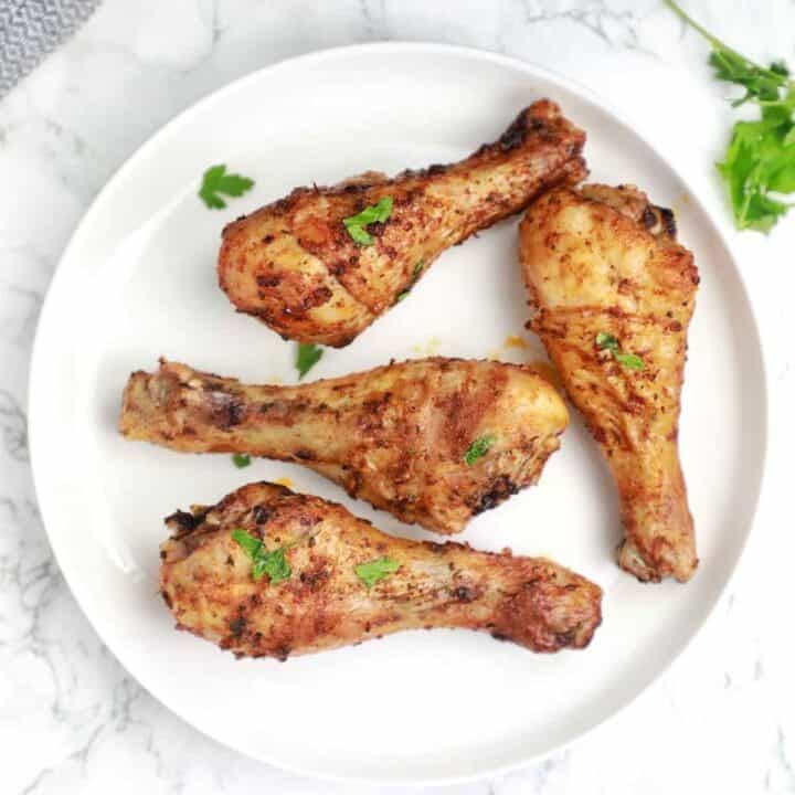 the cooked chicken legs served and garnished with parsley.