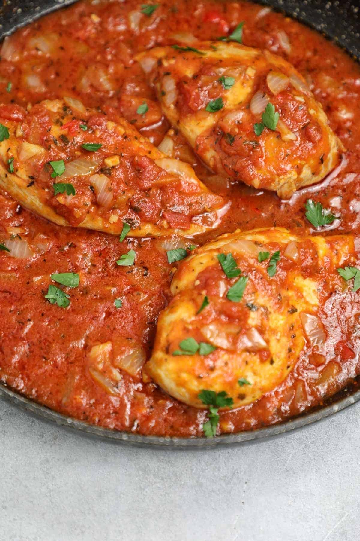 cooked chicken in tomato sauce in a skillet.