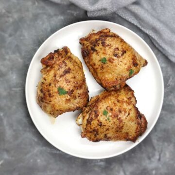 3 pieces chicken thighs on a white plate.