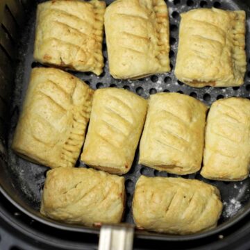 cooked sausage rolls in air fryer basket.