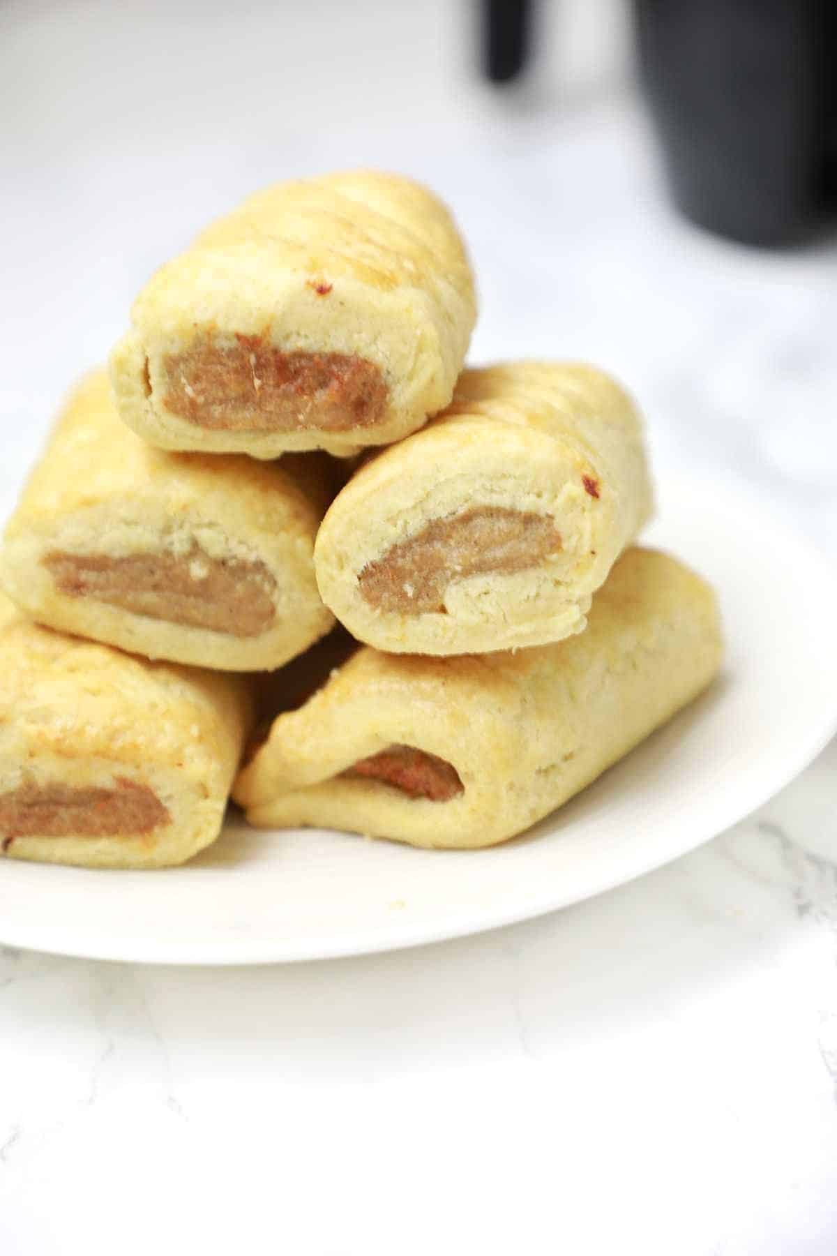 sausage rolls served on a white plate.