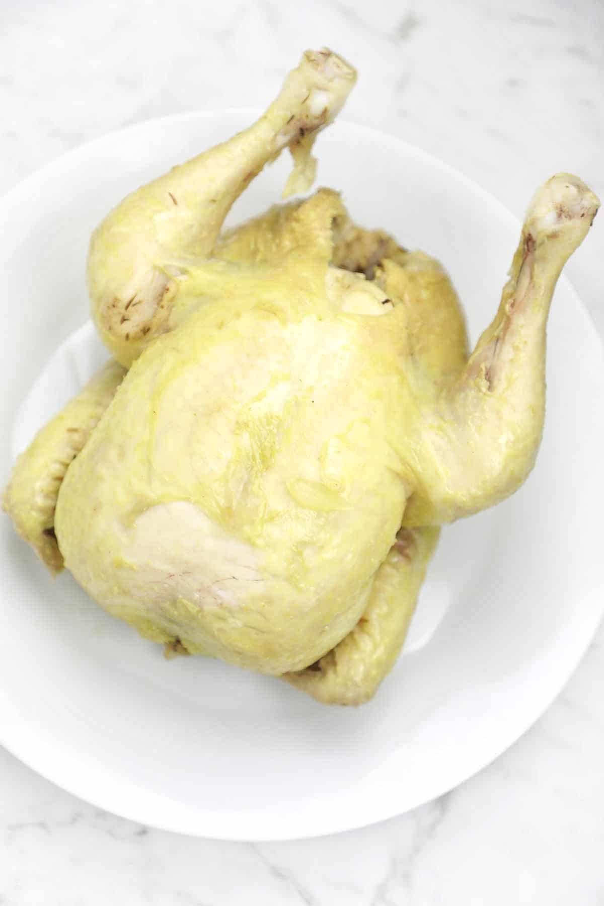 boiled whole chicken on a plate.