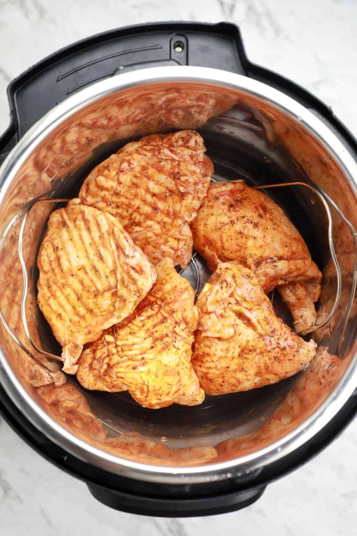 chicken thighs arranged on trivet in the instant pot.