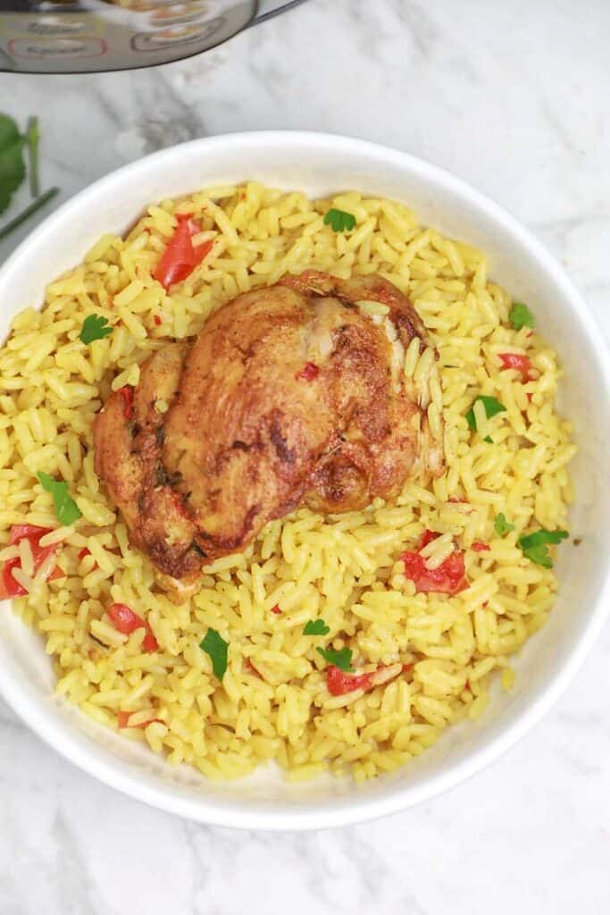chicken and rice served on a plate.
