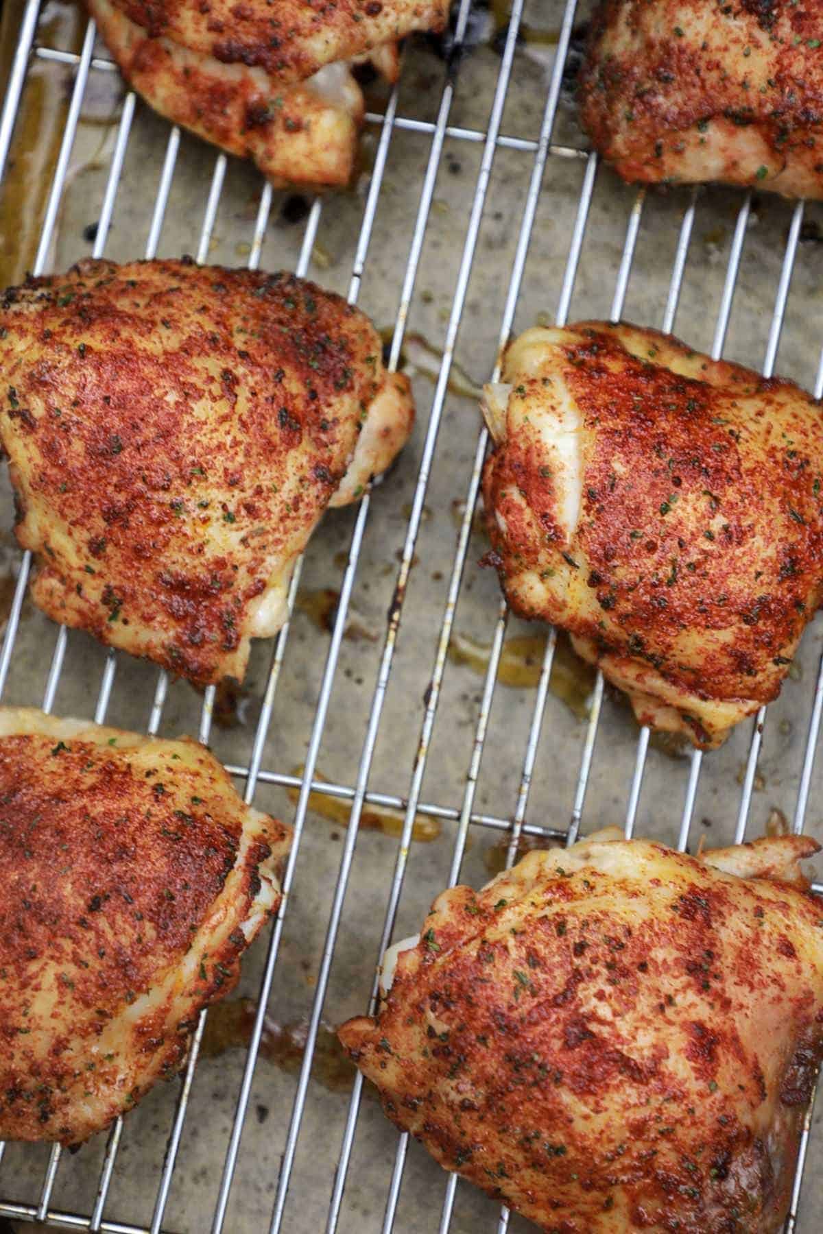 dry rub chicken thighs displayed on baking rack.
