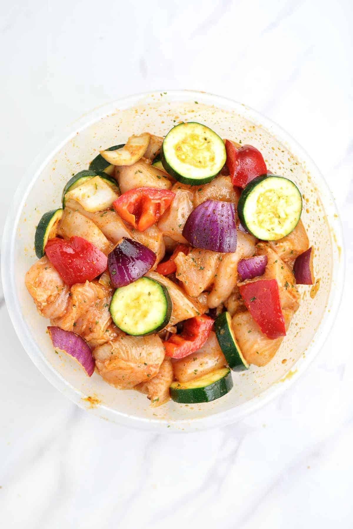 chicken and the veggies marinated in a bowl.