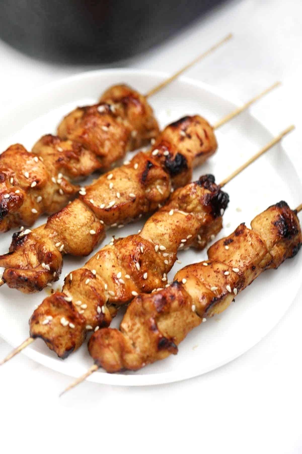 Chinese chicken on a stick served and garnished with sesame seeds.