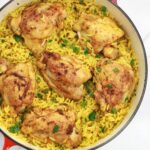 yellow rice and chicken in a pot.