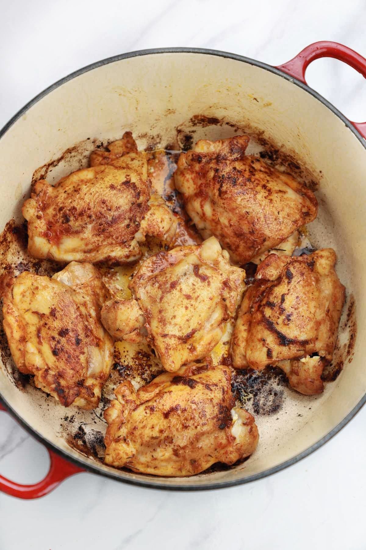 browned chicken thighs in a pot.