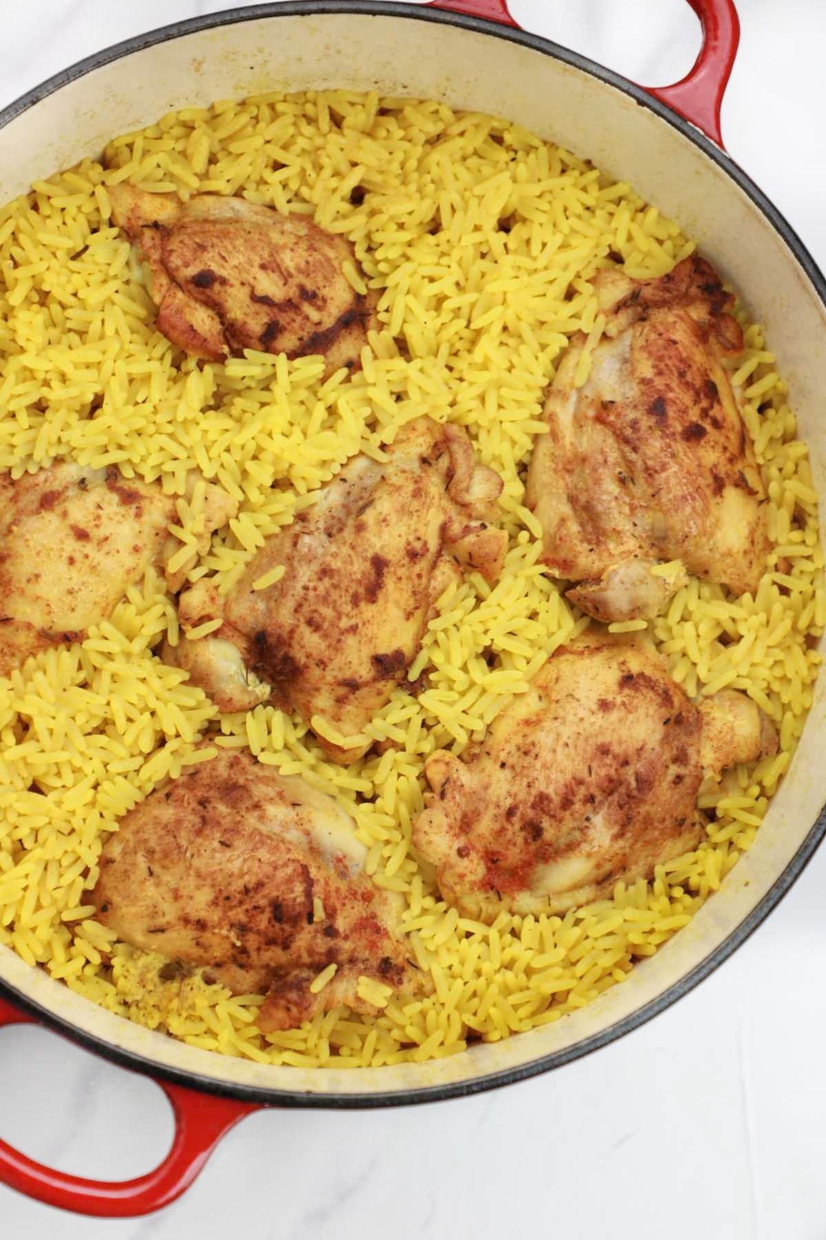 cooked chicken and yellow rice in a pot.