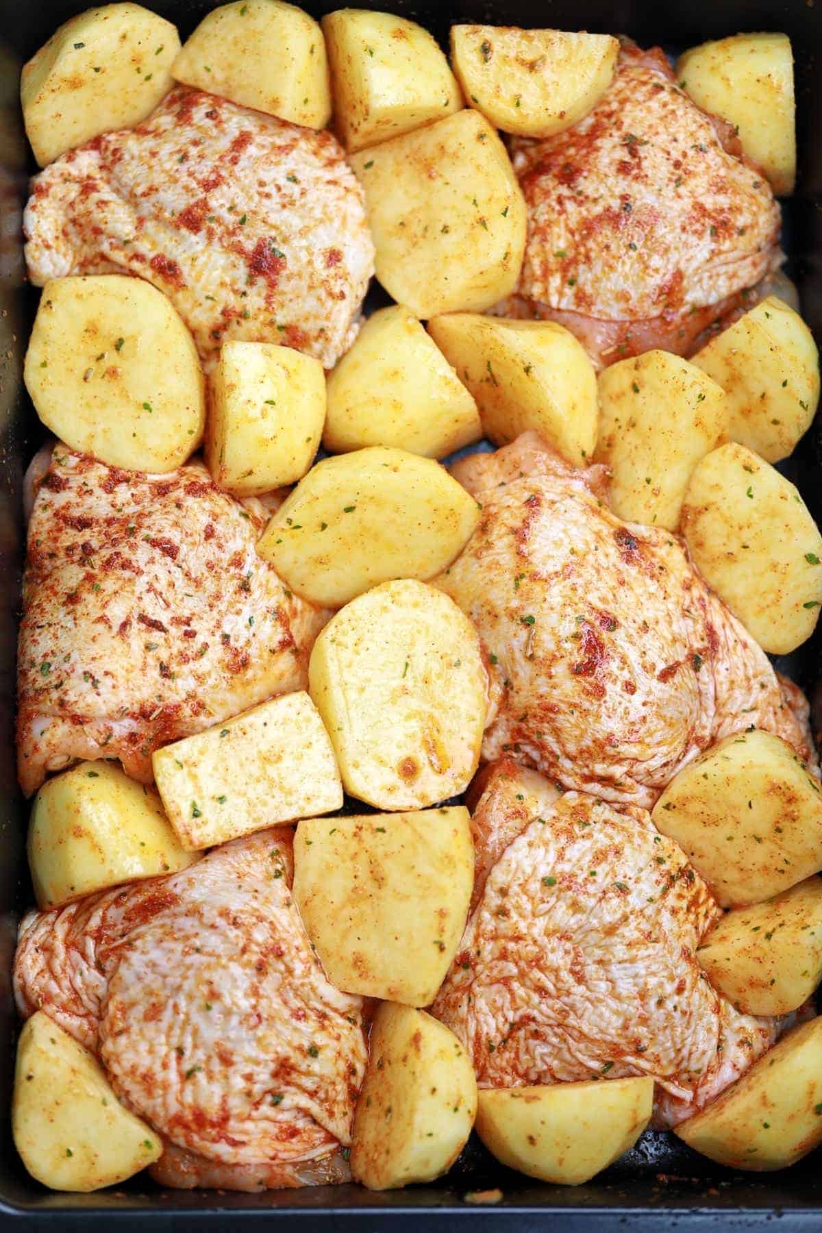 chicken and potatoes in a baking pan.