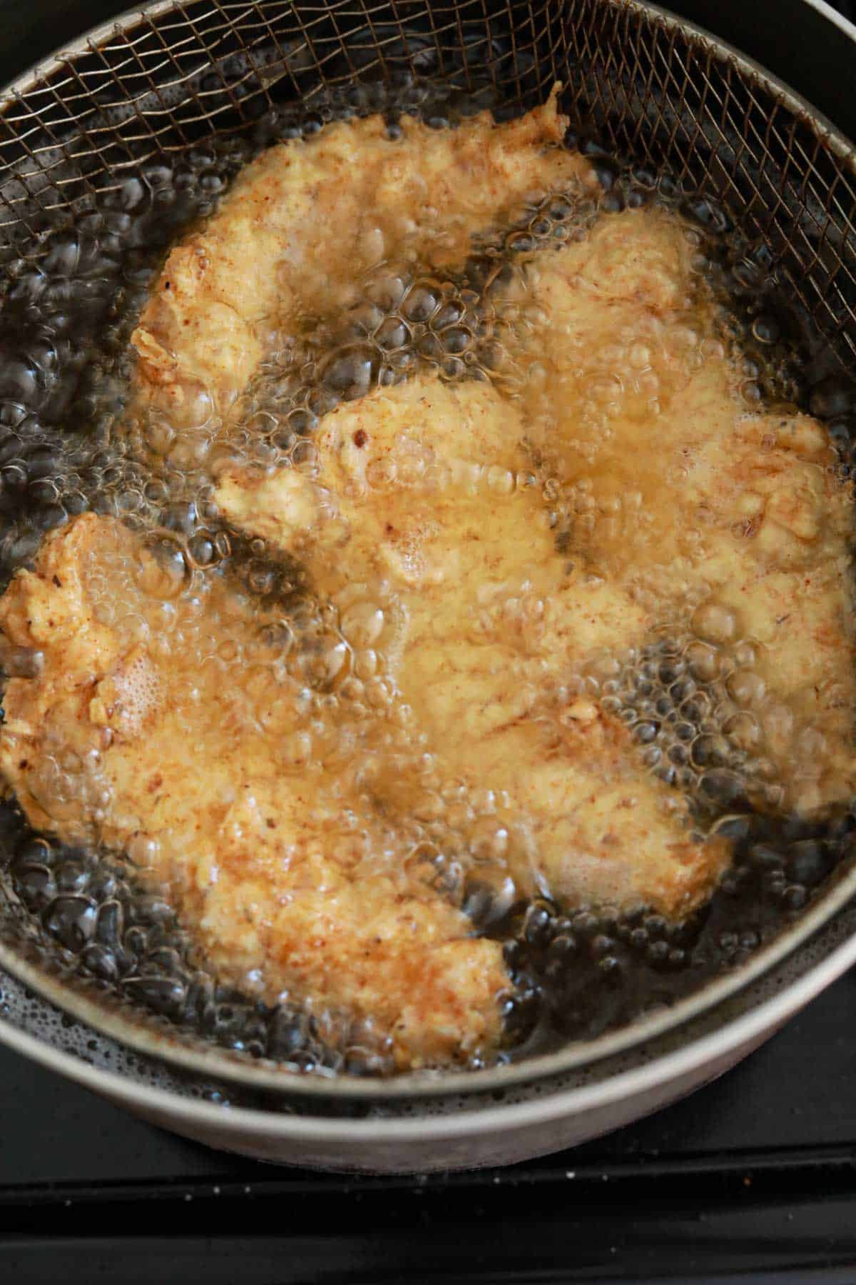 chicken tenders frying in oil.