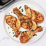 lemon pepper chicken drumsticks on a plate and in baking tray.