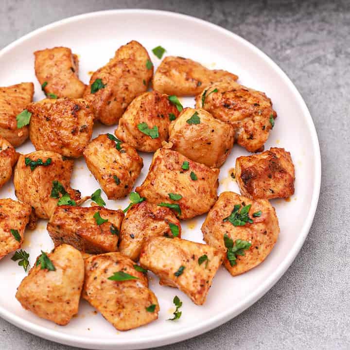 chicken pieces served on a plate and garnished with parsley.